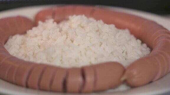 白米饭和切成螺旋状的香肠放在盘子里旋转