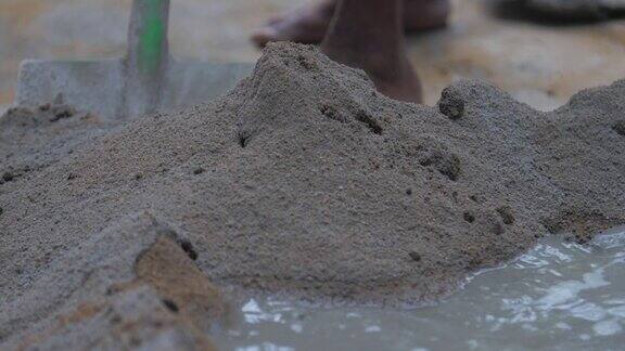 人们用金属铲搅拌水泥和水