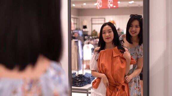 亚洲华人女性在服装零售店购物和浏览