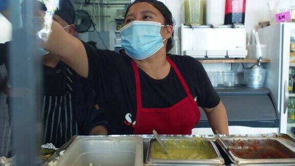 2019冠状病毒肺炎一级防范禁闭期间厨师戴着口罩和手套在厨房工作