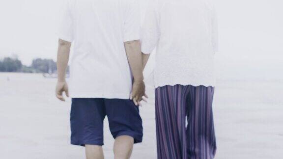 亚洲老夫妇一起在海边散步在周末假期的背景老年人幸福生活