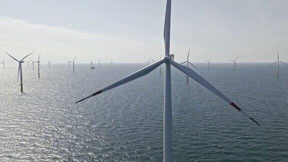 空中旋转的风力涡轮机在阳光下的海上