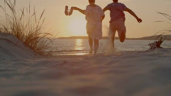 一对情侣在撒丁岛的海滩上奔跑