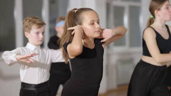 美丽的小女孩在舞蹈学校和同学跳舞的慢镜头可爱可爱的孩子在室内排练交际舞人才和技能