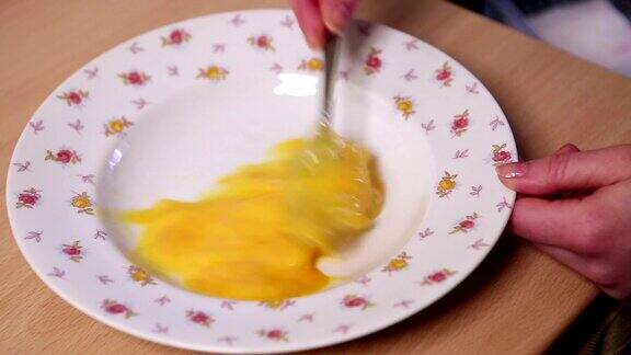 在盘子里搅拌生鸡蛋