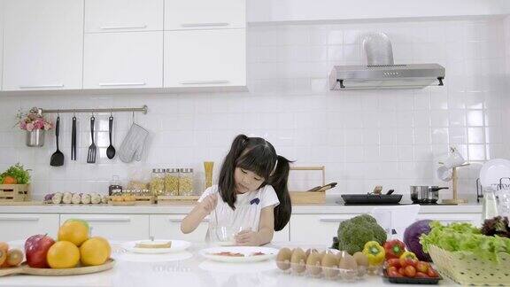 亚洲小女孩正在家里的厨房里吃早餐麦片加牛奶健康食品理念为了增强身体的力量