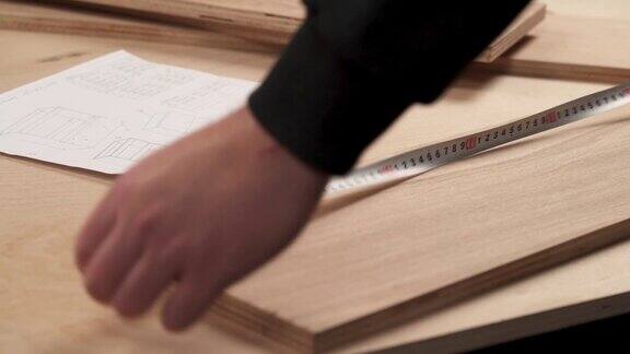用卷尺测量工件的人的手的正面视图