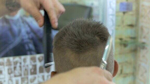 专业发型师在理发店用剪刀为小男孩剪头发