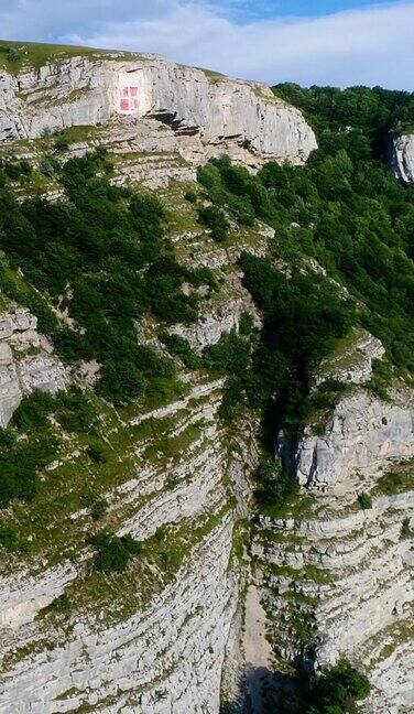 垂直视频的空中拍摄的石灰岩垂直悬崖与树木