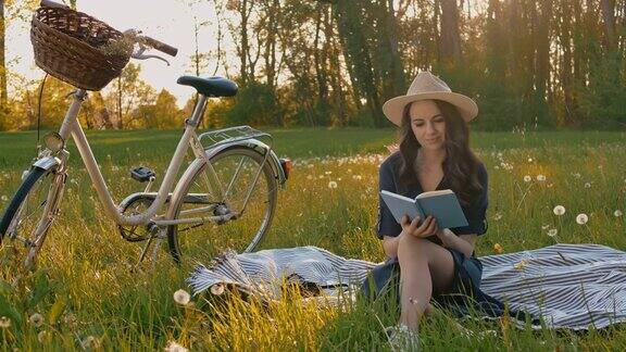 在草地上读书的年轻女子