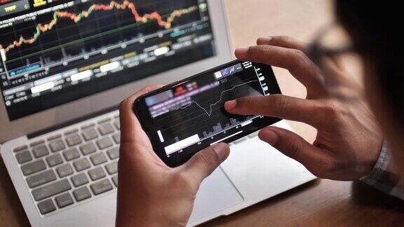 一个男人用智能手机分析正在看中的股票市场