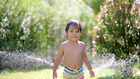 SLOMO亚洲婴儿玩水微笑和看镜头