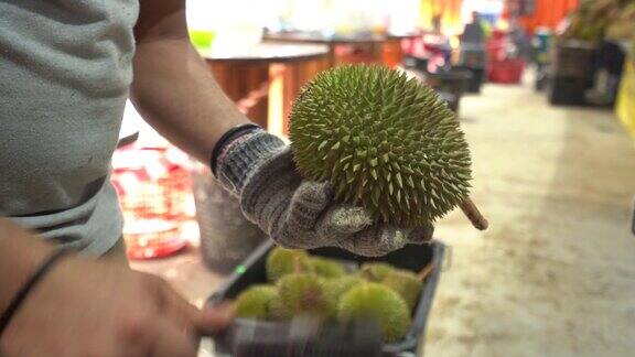 小贩在马来西亚市场商店打开新鲜榴莲