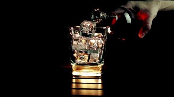 酒吧间招待员将威士忌倒入装有冰块的玻璃杯中在木桌和黑色的背景下专注于冰块威士忌放松的时间
