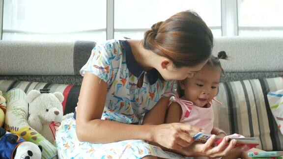亚洲宝宝和妈妈一起玩和看书