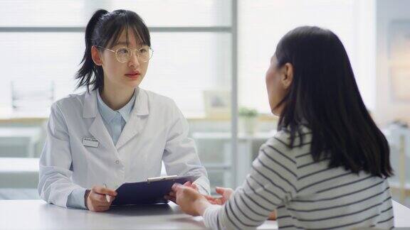 亚洲医生在门诊为女病人提供咨询