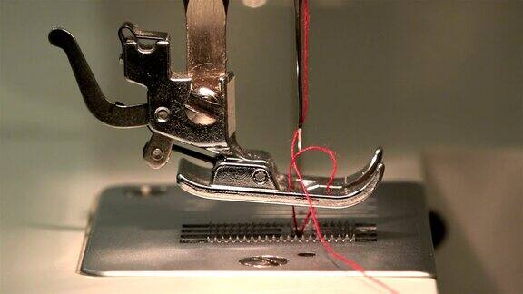 裁缝将针穿过针板在缝纫机上做成一个线圈