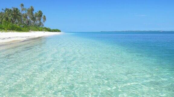 白色的沙滩、蓝绿色的海水和地平线上的小岛