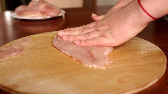 女厨师在木板上切生鸡肉
