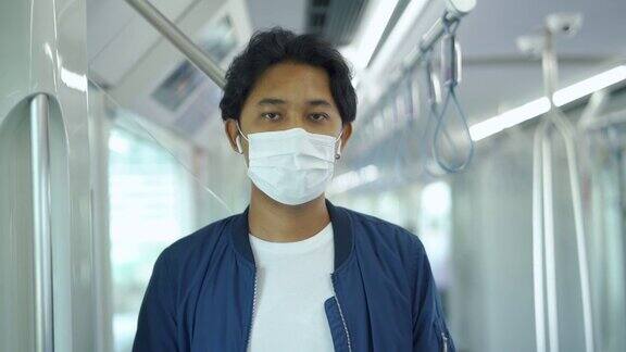 亚洲男子戴着防护口罩乘坐地铁
