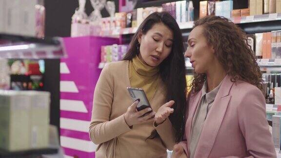 女朋友用智能手机在化妆品店购物
