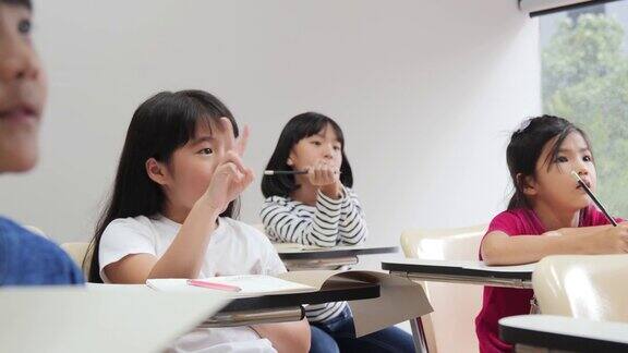 小女孩在教室里回答老师的问题女孩感到高兴当她赢得了智力竞赛