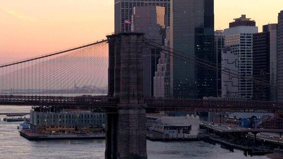著名的布鲁克林大桥映衬着粉红色的天空和玻璃幕墙的摩天大楼