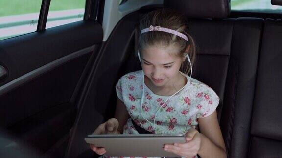 孩子在车里用平板电脑玩网络游戏