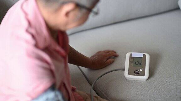 亚洲华人老年男子正在监测血压