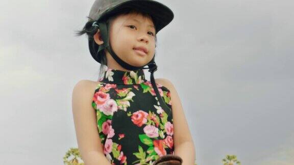 小女孩骑着马在乡村的路上