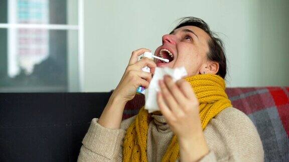 生病的年轻女子使用喉咙喷雾剂