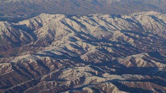 山上的鸟瞰图从飞机窗口观看阿富汗的兴都库什山脉