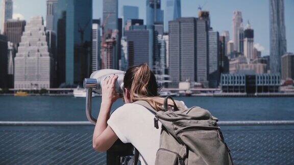 后视图年轻的女游客透过投币式双目望远镜看曼哈顿城市全景慢镜头