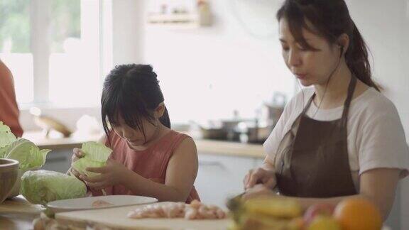 顽皮可爱的亚洲华人女儿在厨房帮妈妈准备食物