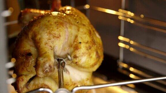烹饪烤鸡在烤架上吐在热烤箱的特写