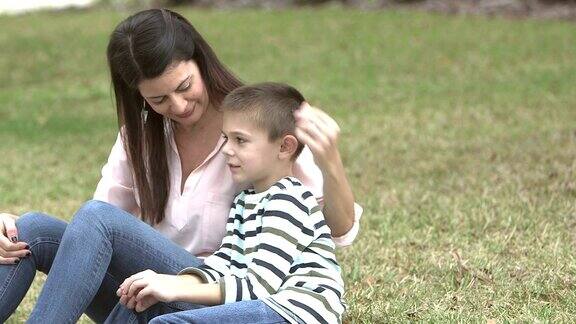 母亲和儿子在草坪上聊天