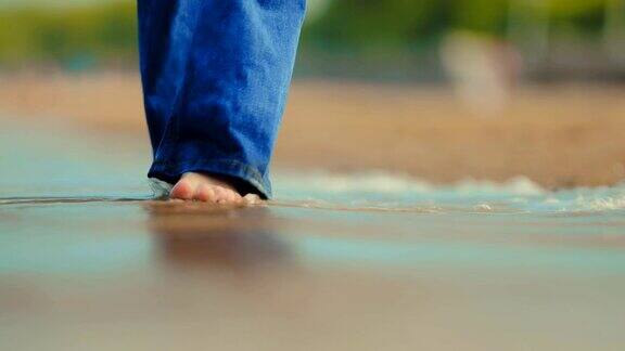 海浪在岸边打湿了他们的光脚女孩在海里特写镜头