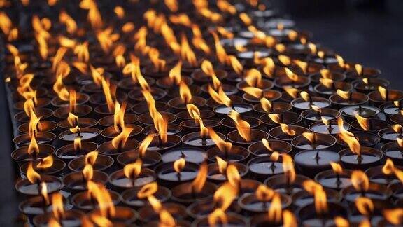 尼泊尔一座佛教寺庙旁点燃多支仪式蜡烛慢动作特写镜头