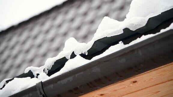 雪在屋顶排水沟上融化
