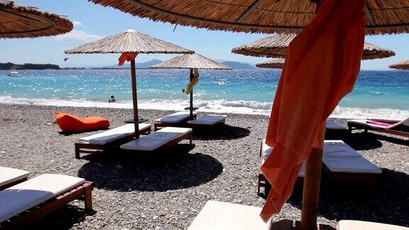 豪华时尚的躺椅带伞的日光浴床在沙滩上放松
