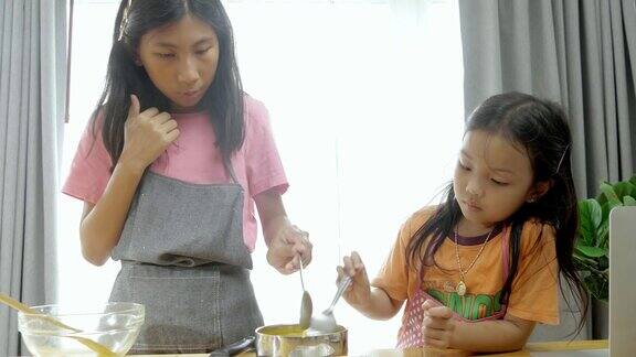 亚洲孩子在网上看如何在家一起做橘子果冻