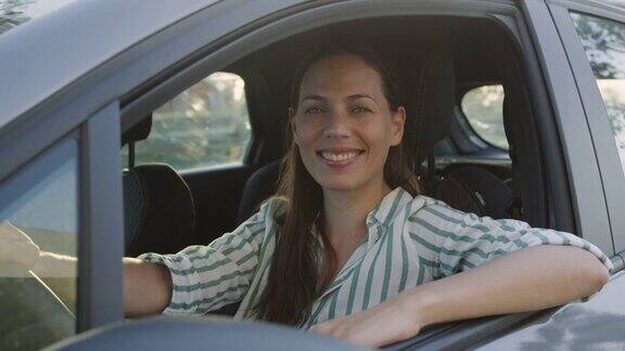一个快乐的成年妇女坐在车里把胳膊肘靠在窗户上
