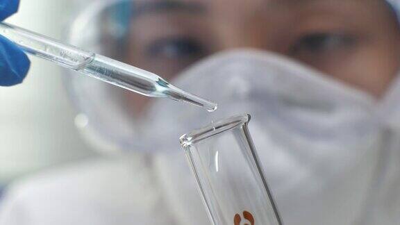 在实验室里把液体从移液管移到试管中的科学家