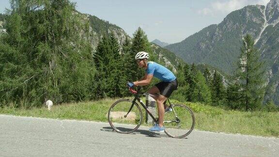 慢动作:适合男性自行车手毫不费力地骑上陡峭的阳光下的柏油路