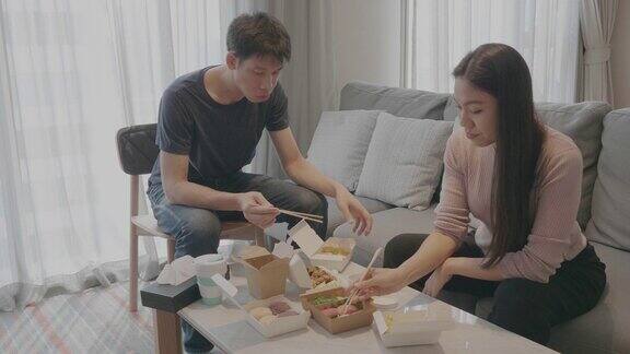 俯视图亚洲中国年轻家庭享受外卖食品在电视前的客厅周末