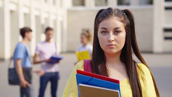 女学生在大学大楼附近摆造型