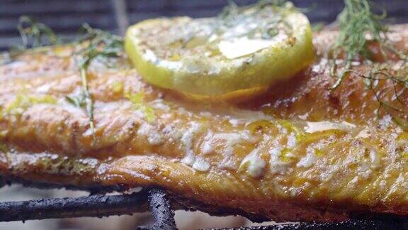 火烤架上的野生鲑鱼片配上柠檬片和香草
