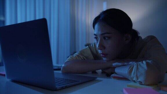 亚洲商务女性穿着休闲服装晚上在家里客厅看笔记本电脑近距离射杀