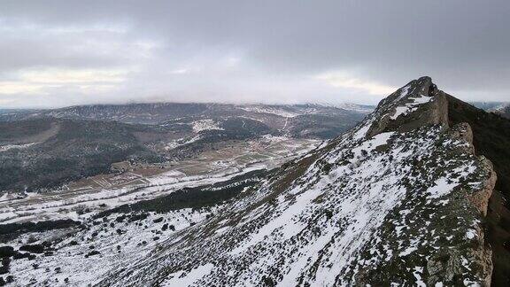 多云天空下雪山景观鸟瞰图冬天的无人机视频高质量4k镜头