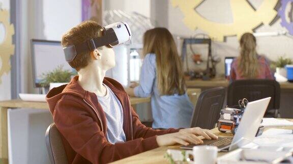 在计算机科学课上戴着虚拟现实耳机的男孩正在做一个编程项目